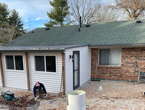 Skilled roofers replacing worn shingles on a residential property